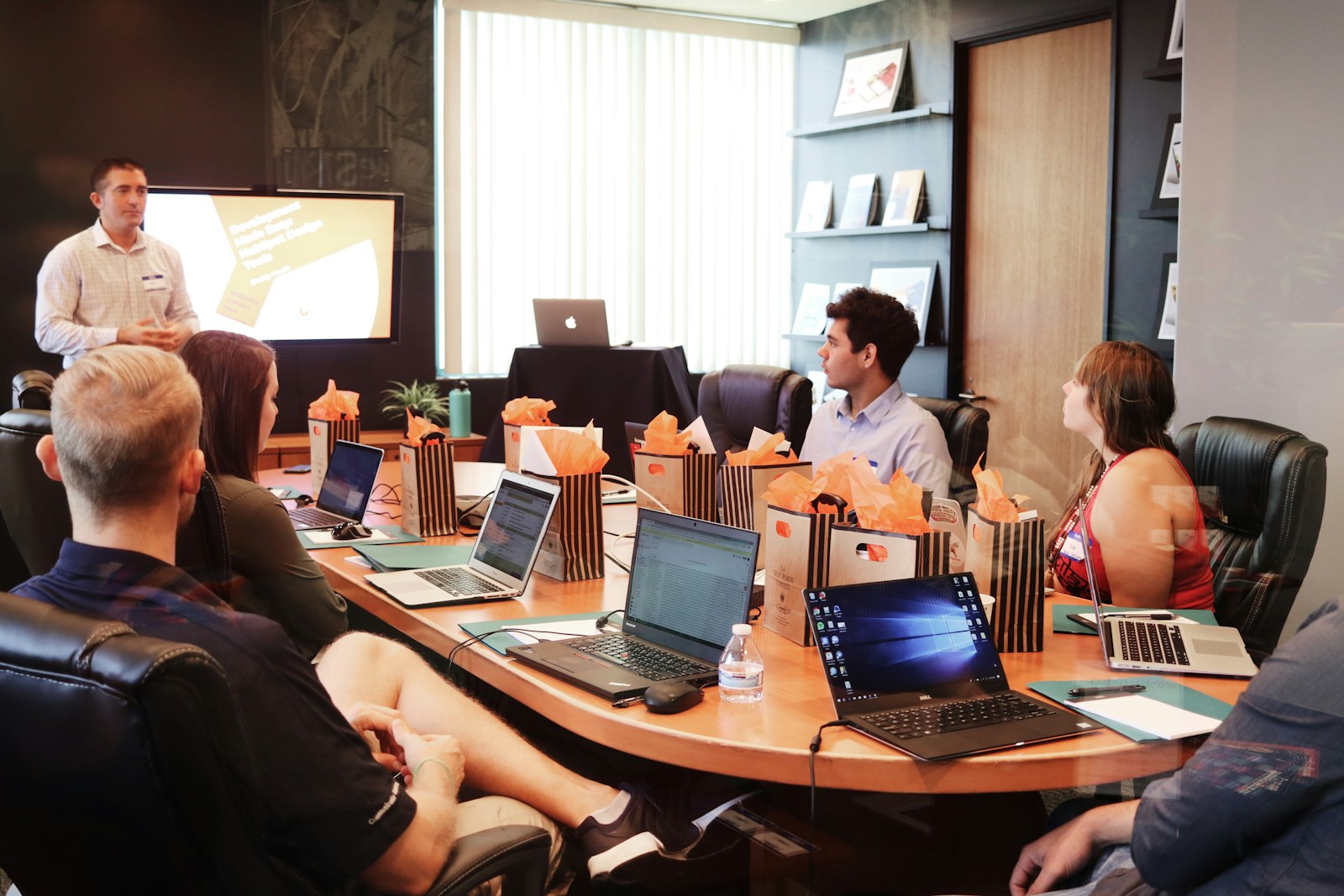 Product team in a conference room reviewing a presentation on laptops